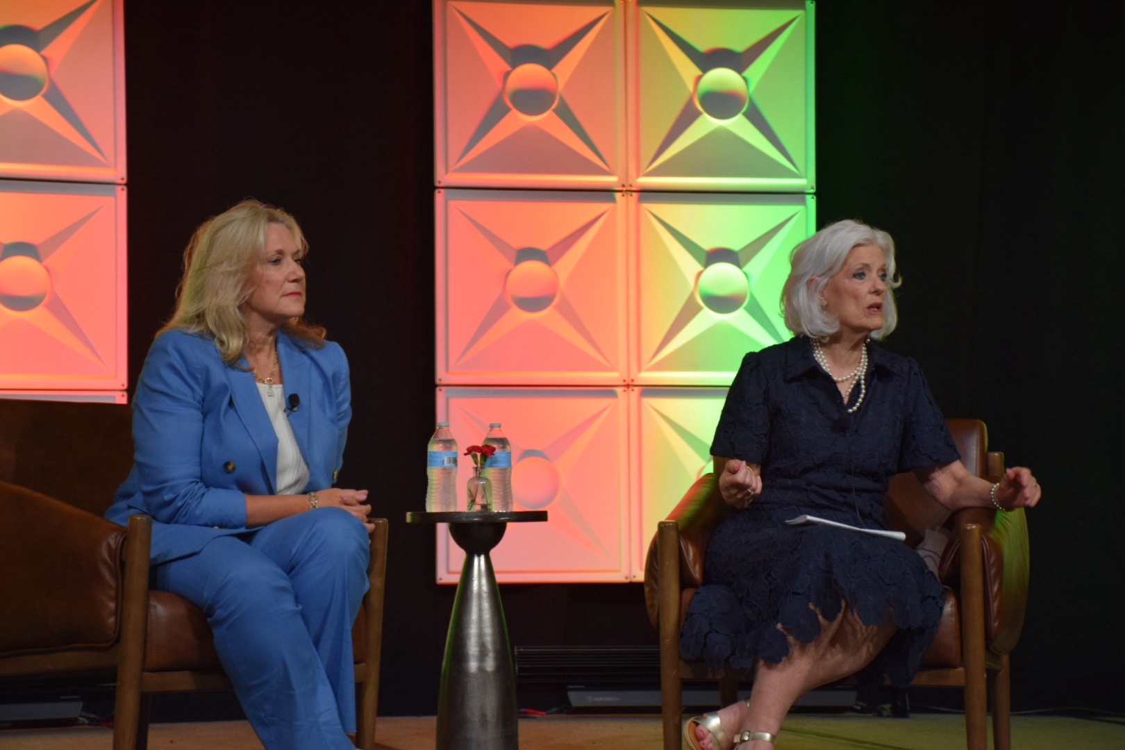 Stephanie J. Bond in a blue suit during a fireside conversation on stage